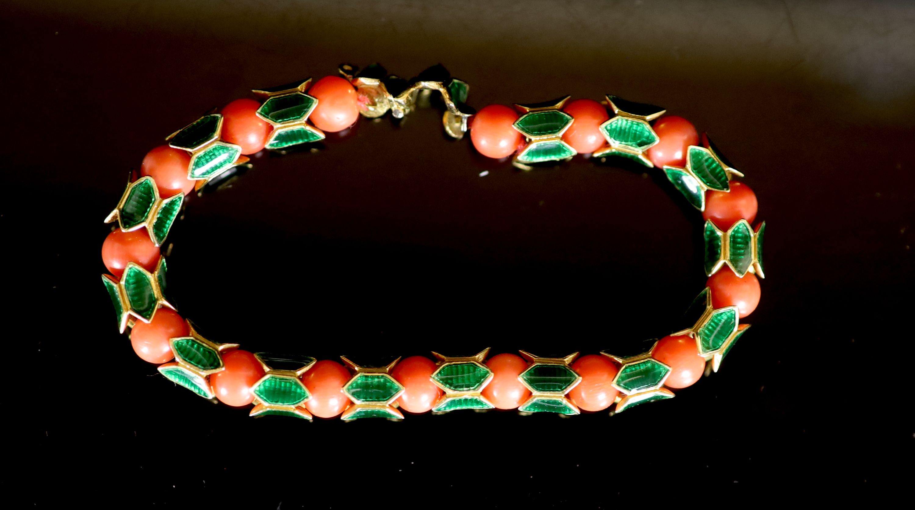 A good 1950's Cartier gold, coral bead and green enamel set articulated bracelet